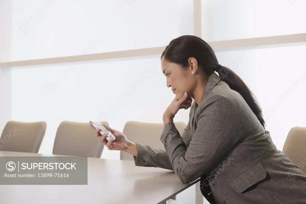 Asian businesswoman looking at electronic organizer