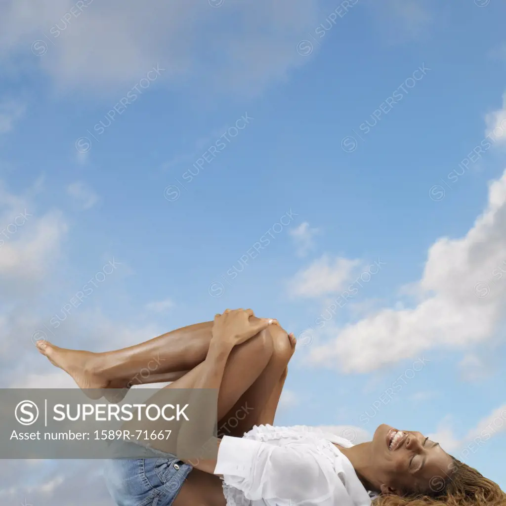 African woman laying on back laughing 