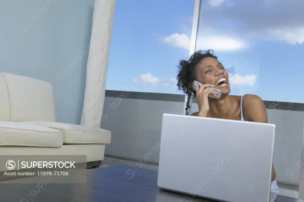 African woman laughing on cell phone