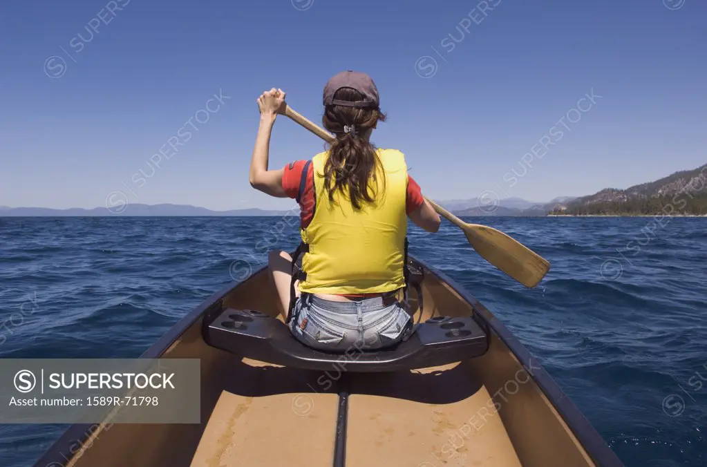 Rear view of woman paddling canoe