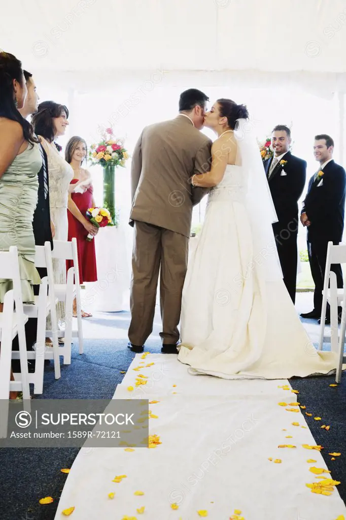 Bride kissing father in aisle