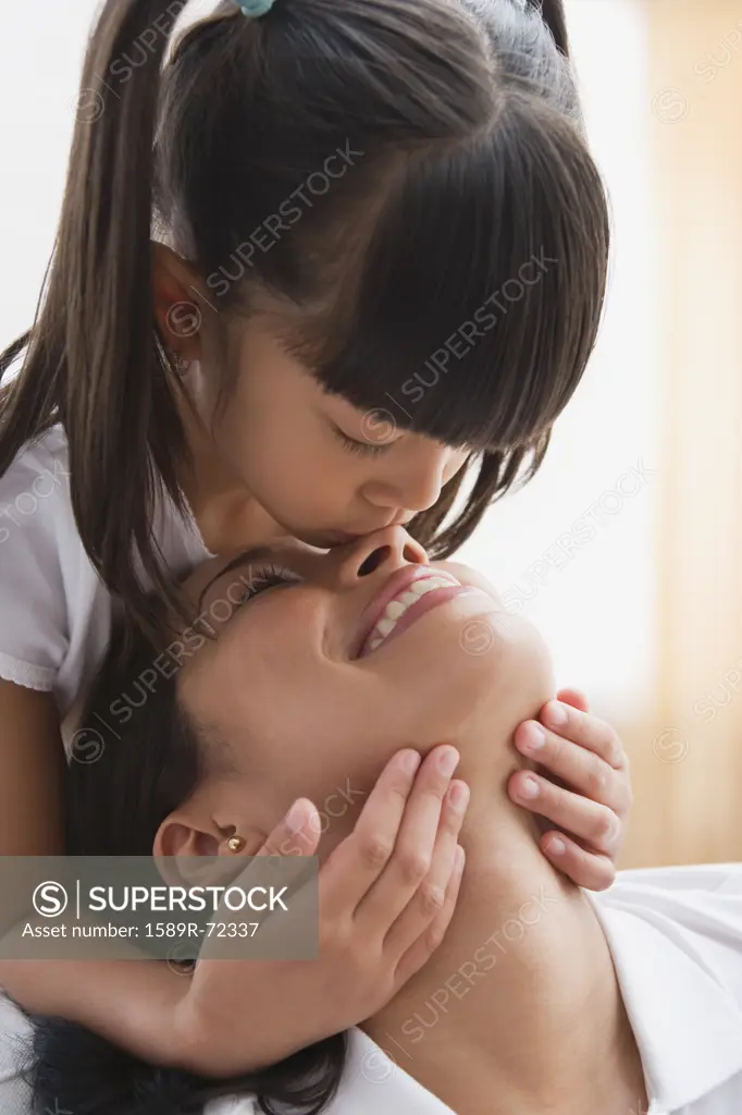 Pacific Islander girl kissing mother's nose