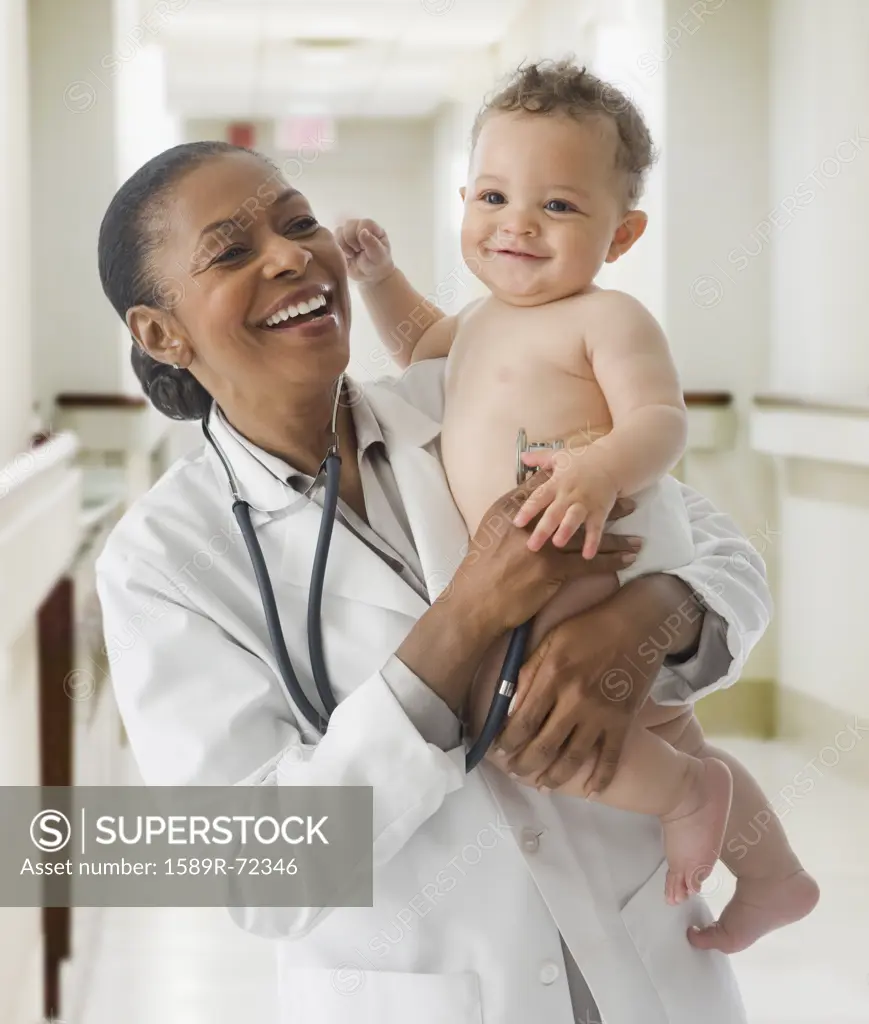 African American female doctor holding baby