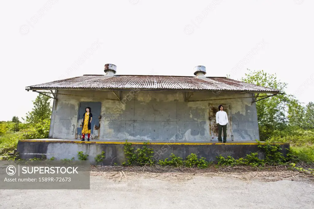 Asian couple standing on opposite sides of porch