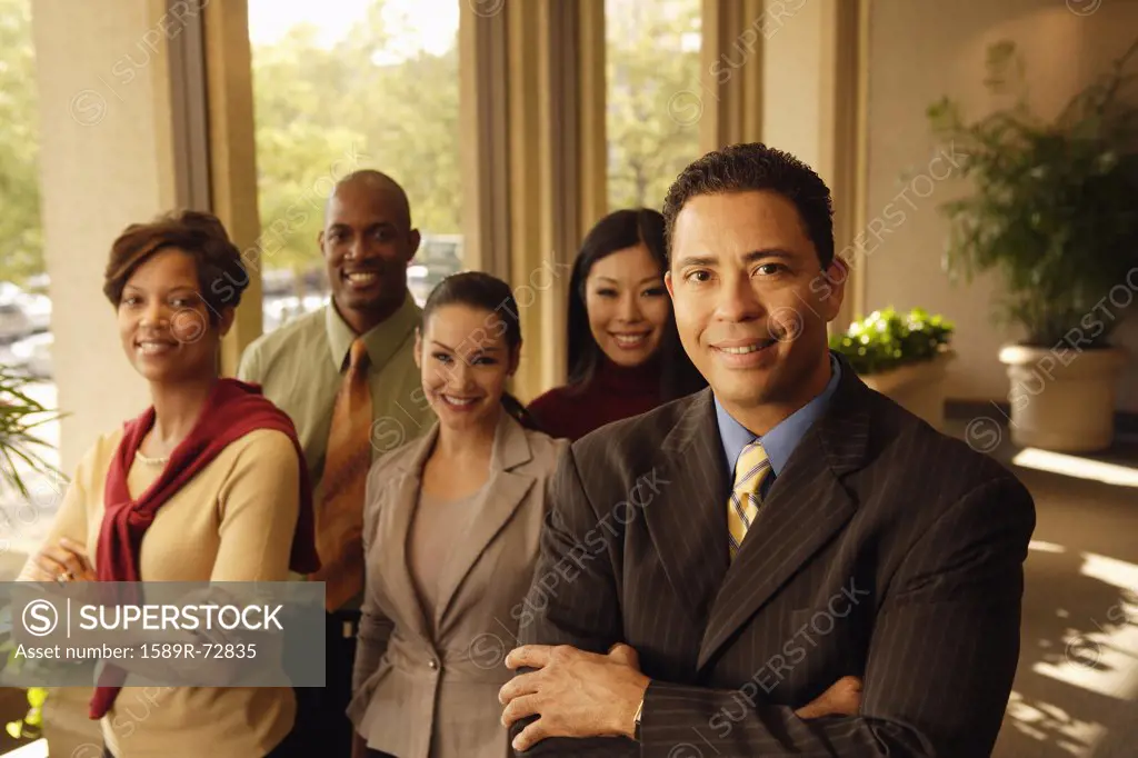 Hispanic businessman in front of coworkers