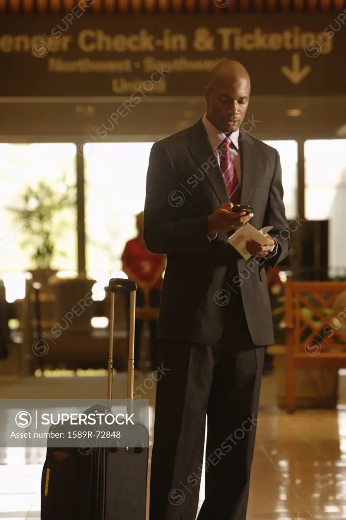 African businessman dialing cell phone