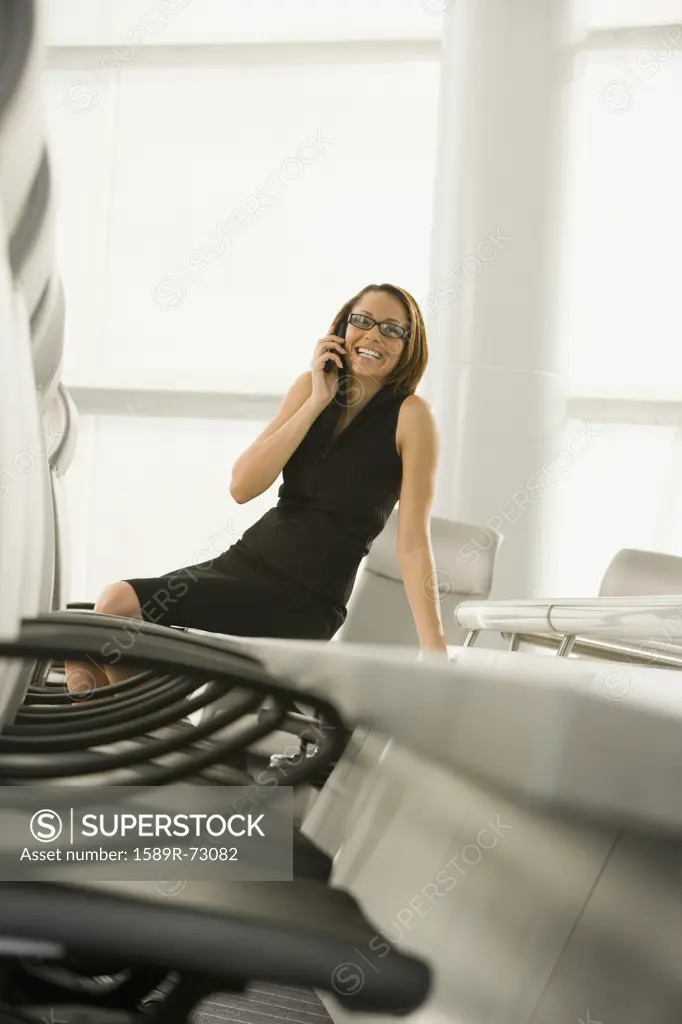 African businesswoman talking on cell phone in conference room