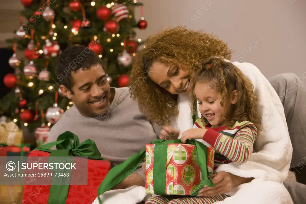 Mixed race family opening Christmas gifts