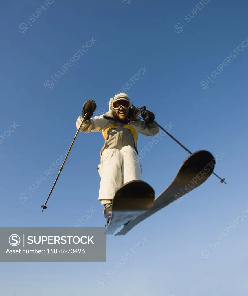 Mixed race woman on skis in mid-air