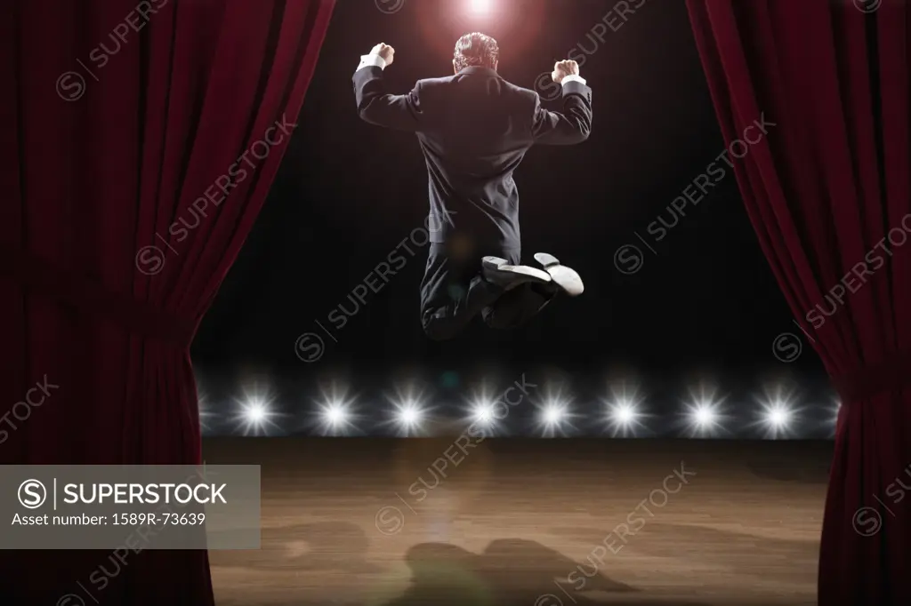 Hispanic man in tuxedo jumping onstage