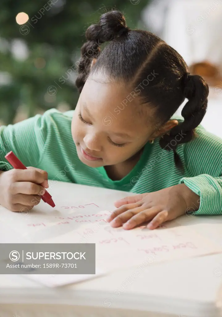 African American girl writing letter to Santa Claus
