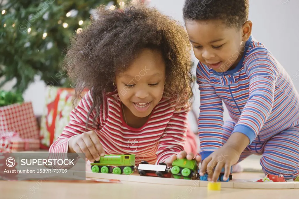 African American brother and sister playing with toy train