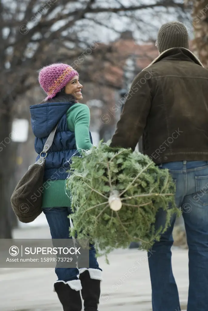 Couple carrying Christmas tree