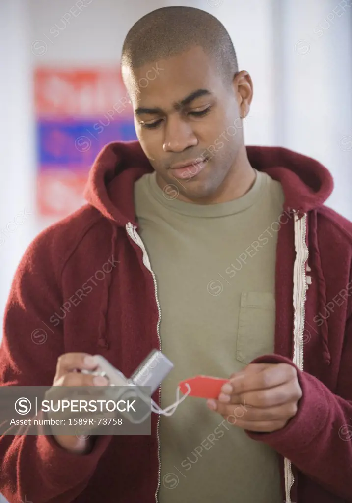 African American man viewing price tag on video camera