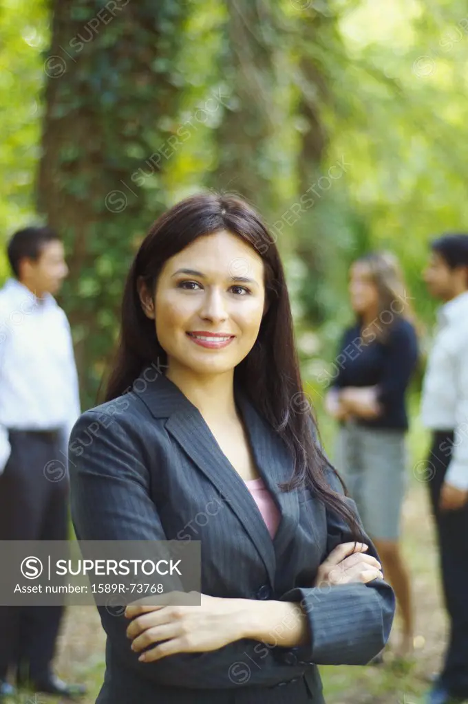 Hispanic businesswoman posing with arms crossed