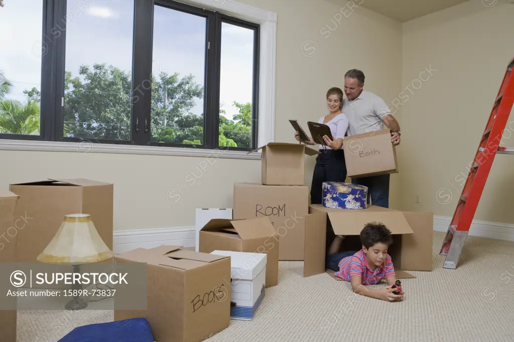 Hispanic family in living room with cardboard boxes