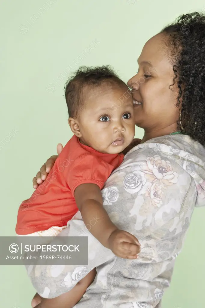 Mixed race mother holding baby daughter