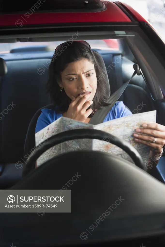 Confused Indian woman in car looking at map