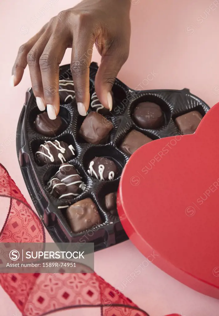 African woman taking chocolates from Valentines box