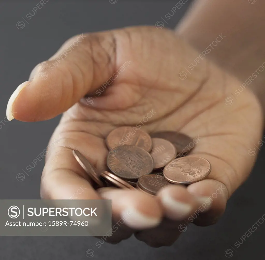 African woman holding handful of pennies