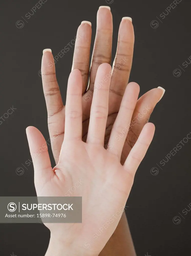 African and Caucasian woman holding hands