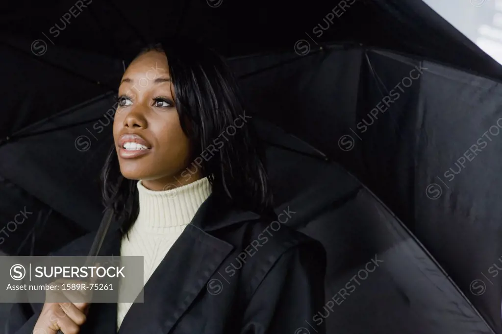African businesswoman holding umbrella