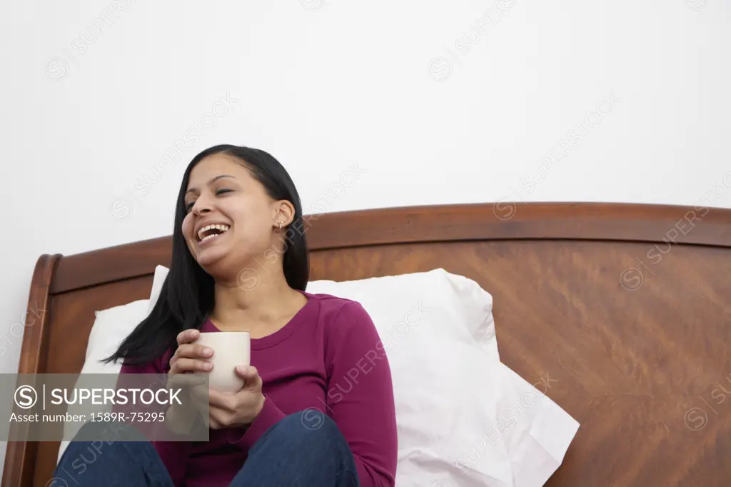Dominican woman drinking coffee in bed