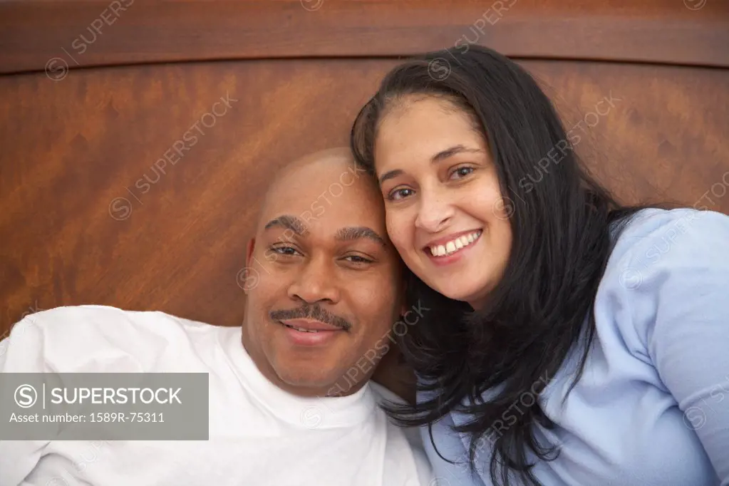 Antiguan man laying in bed with wife