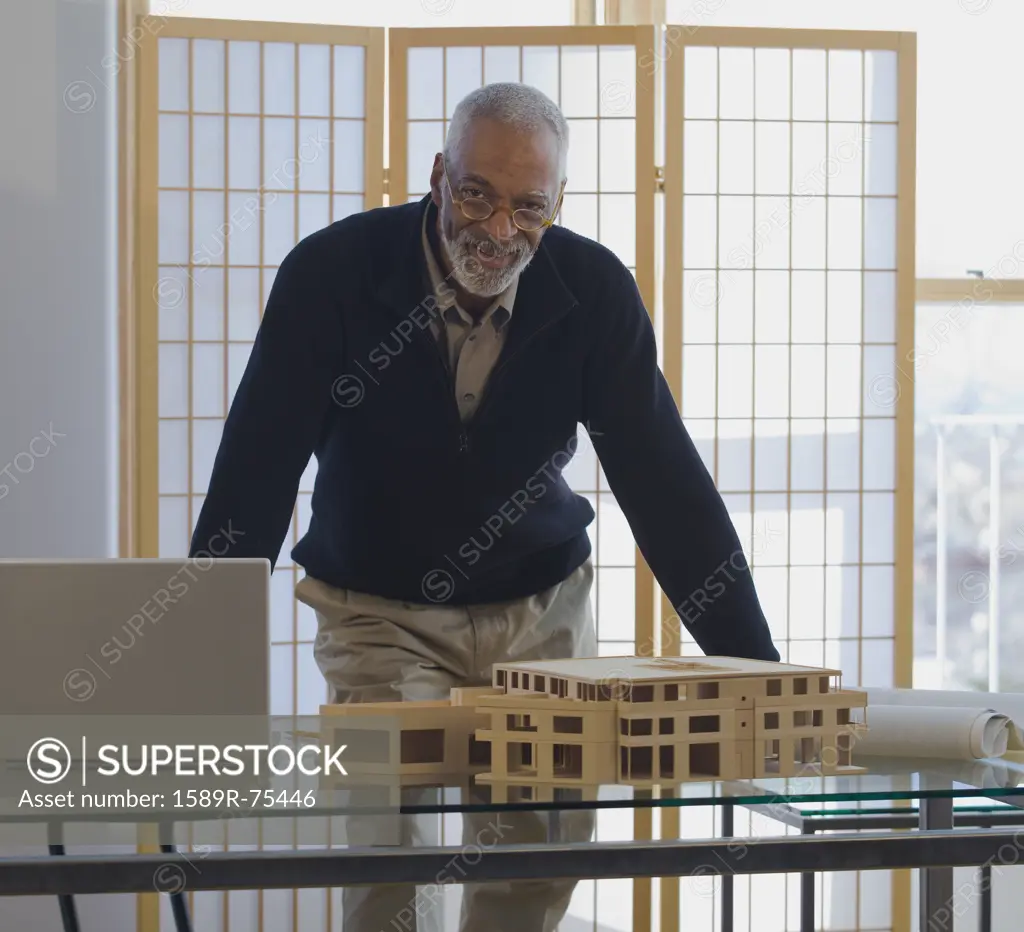 African architect standing with building model