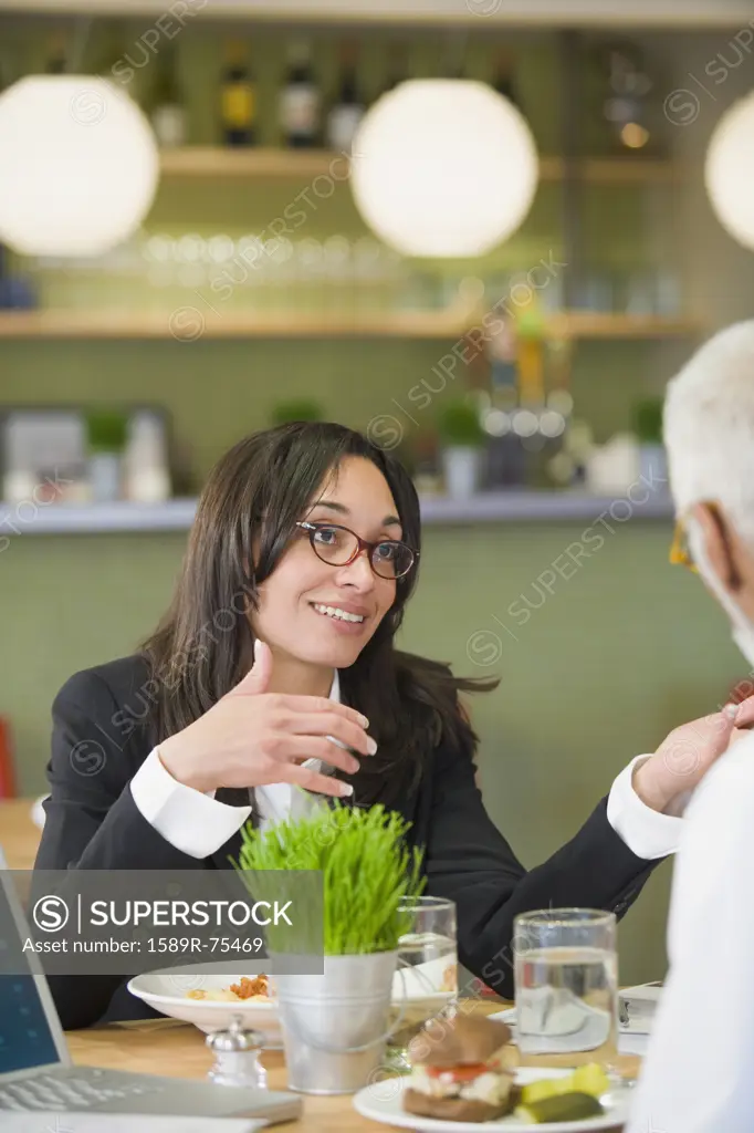 Mixed race businesswoman having lunch with co-worker