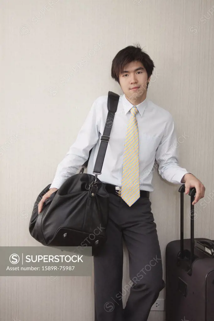 Chinese businessman standing with luggage