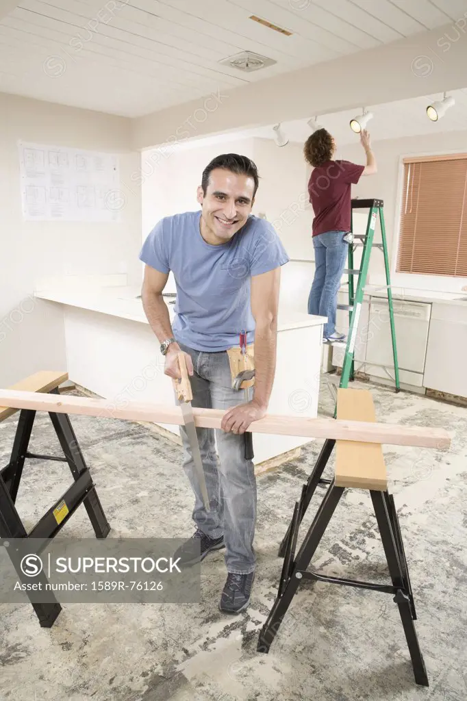 Hispanic man using sawhorse in kitchen