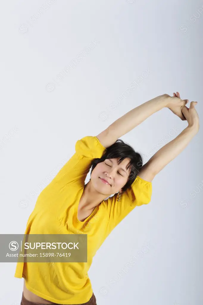 Filipino woman stretching arms overhead