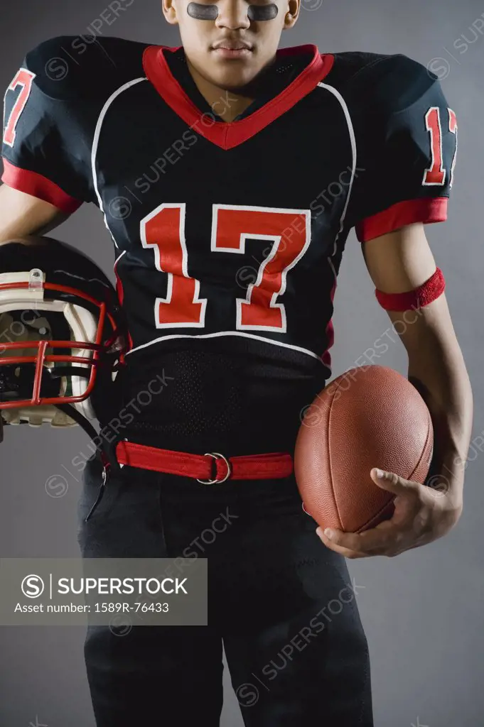 Mixed race football player holding football