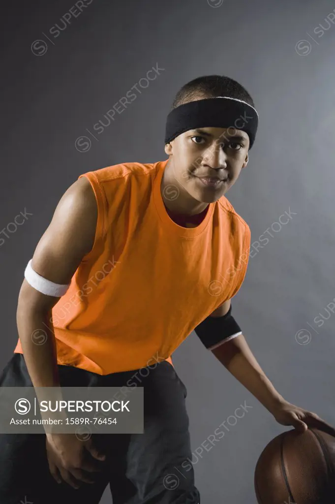 Mixed race basketball player dribbling basketball