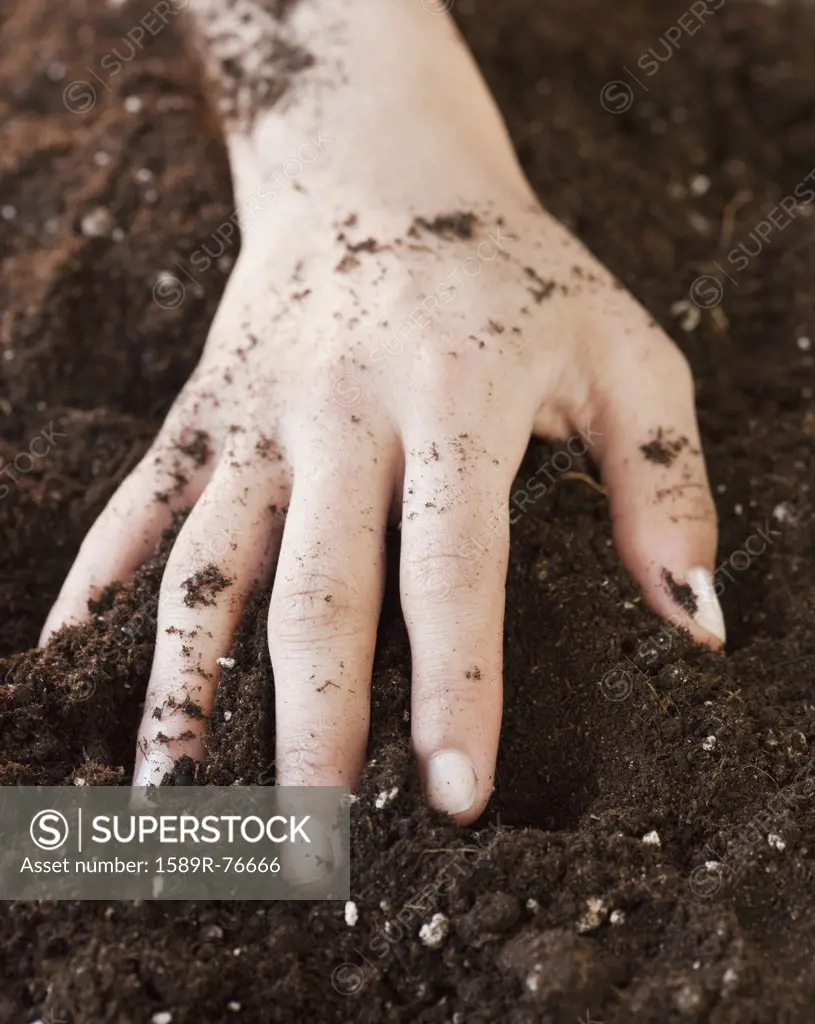 Woman with hand in planting soil