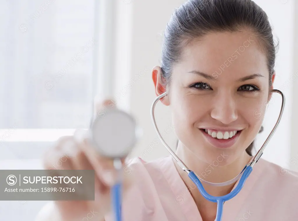 Mixed race nurse holding stethoscope