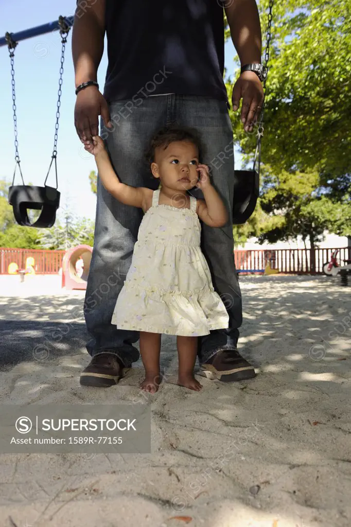 Father and barefoot daughter at playground