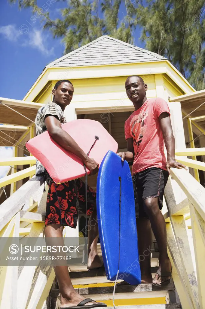 African men holding body boards