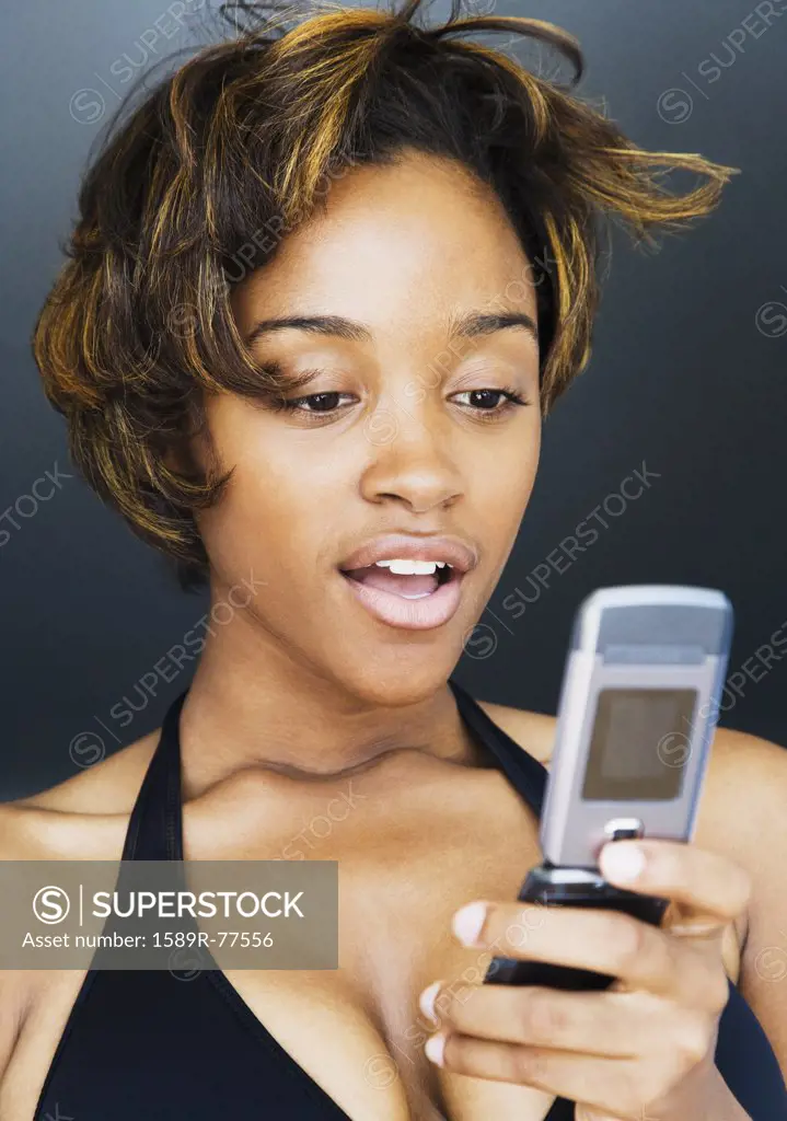 African woman looking down at cell phone