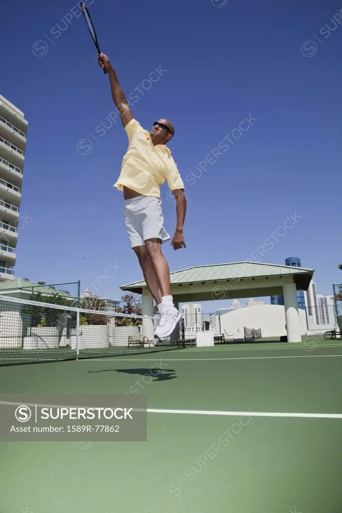 African tennis player jumping with racket