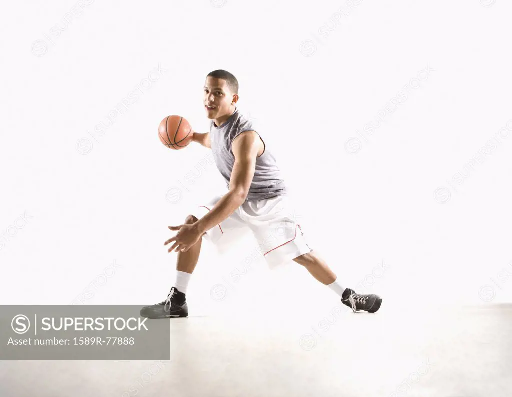 Mixed race basketball player with ball