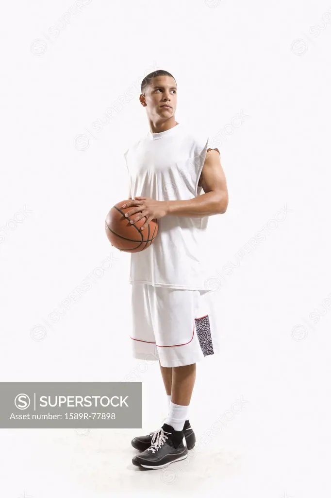 Mixed race basketball player holding ball