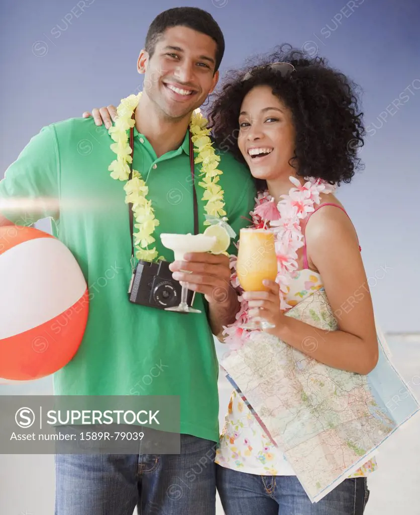 Couple on beach with tropical drinks