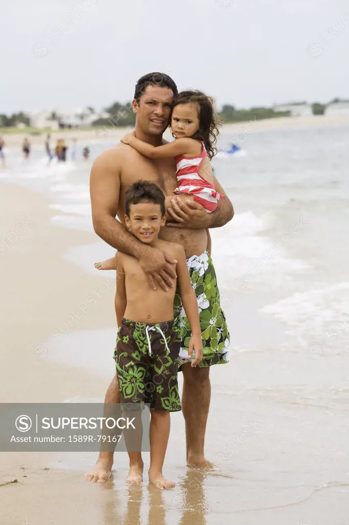 Father with daughter and son on beach