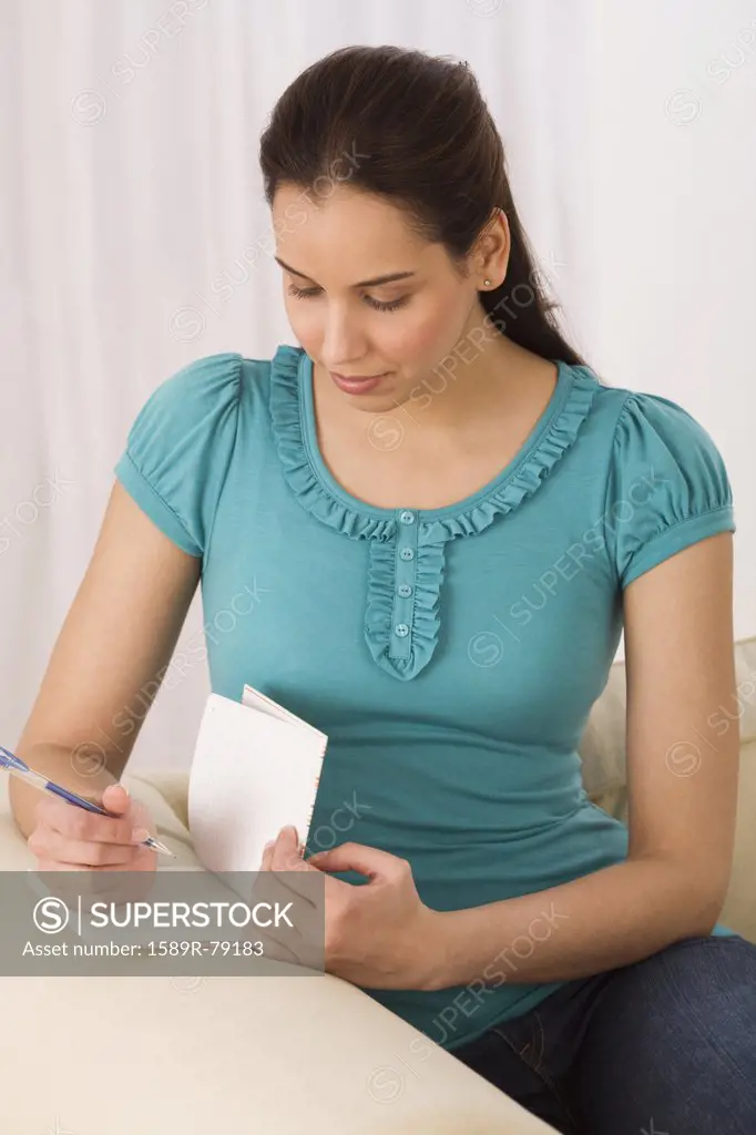 Hispanic woman writing in journal