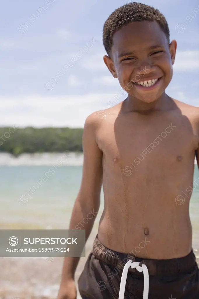 African boy wearing swim trunks on beach
