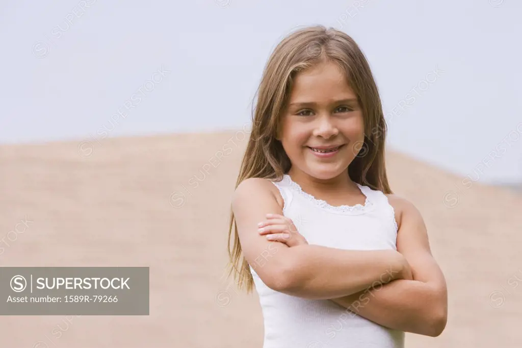 Hispanic girl smiling with arms crossed