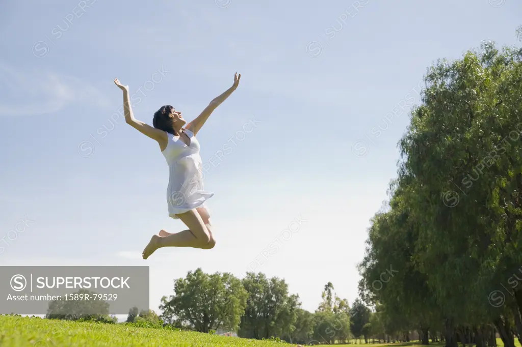 Hispanic woman jumping in mid-air