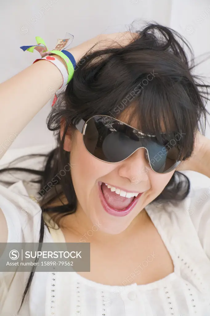 Hispanic woman in sunglasses laughing